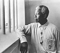 Nelson Mandela standing at prison window
