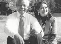 Nelson Mandela wearing a tie and sitting with a young lady.